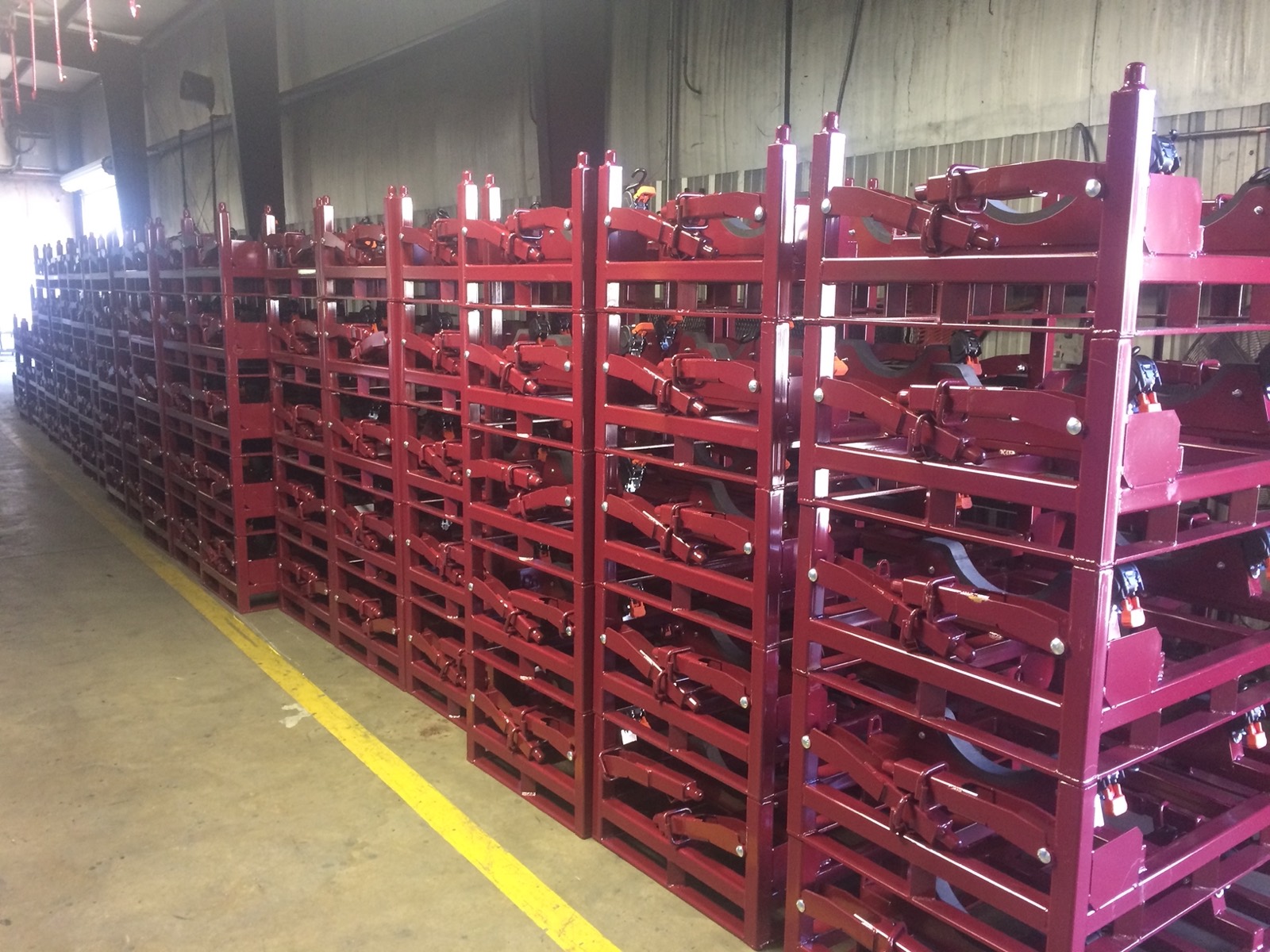 Rows of powder-coated returnable steel racks staged on the Southern Perfection Fabrication shop floor in Byron, GA